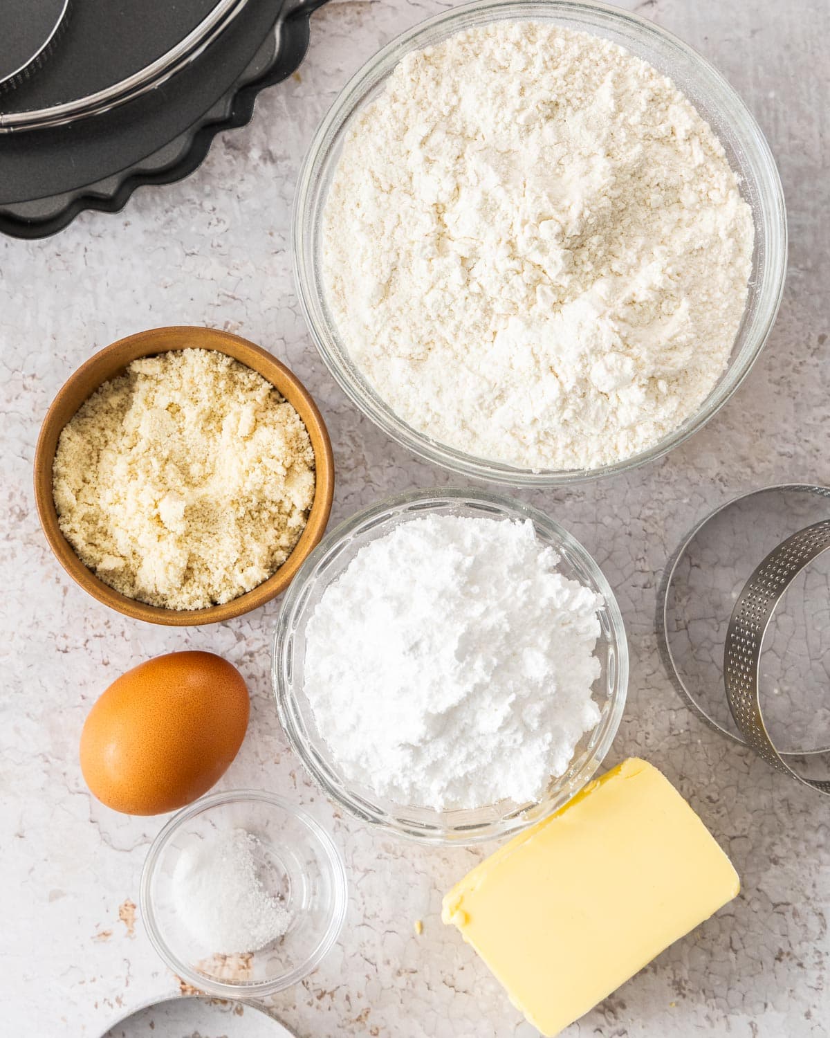 Ingredients for pâte sablée on a cracked plaster background.