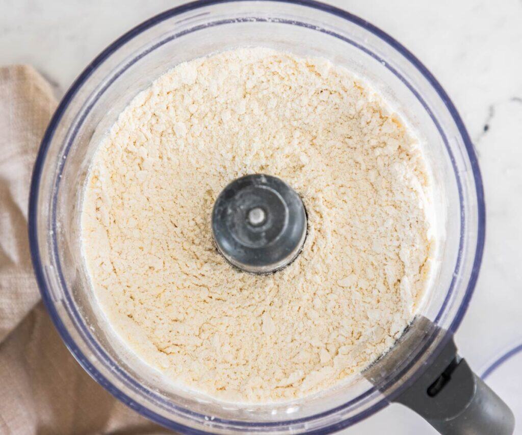 Flour and butter blended together in a food processor bowl.