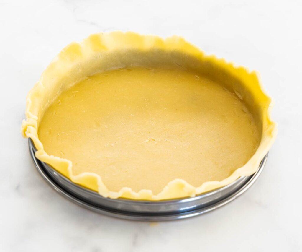 Pastry inside a steel tart ring.