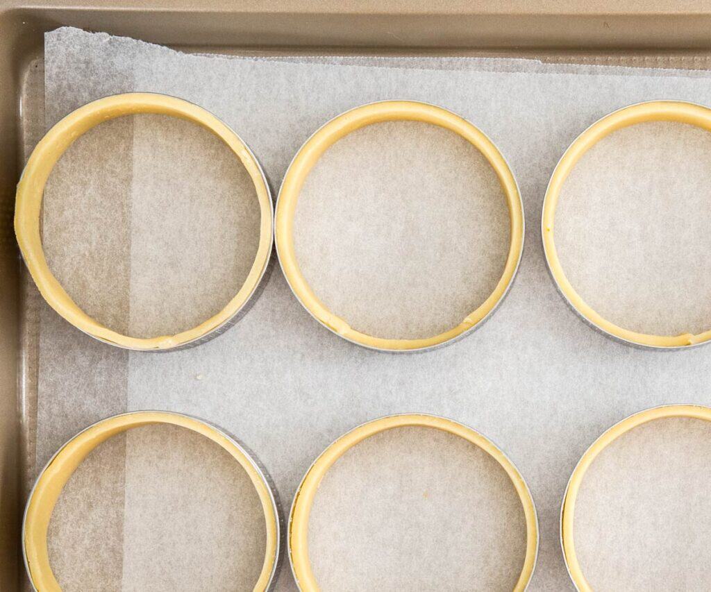 Tart rings with a pastry border around the inside.