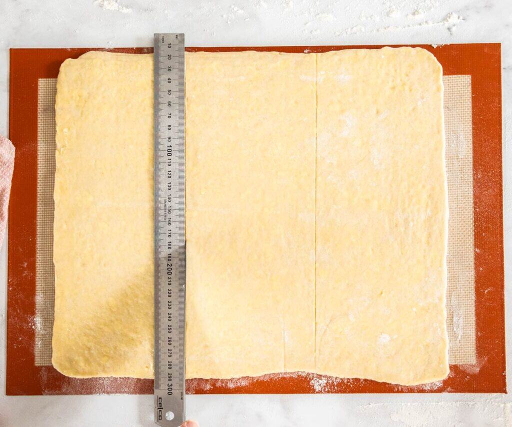 A ruler on the pastry showing how to score the dough into thirds.