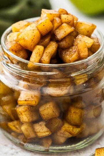 Closeup of a jar overflowing with apple compote.