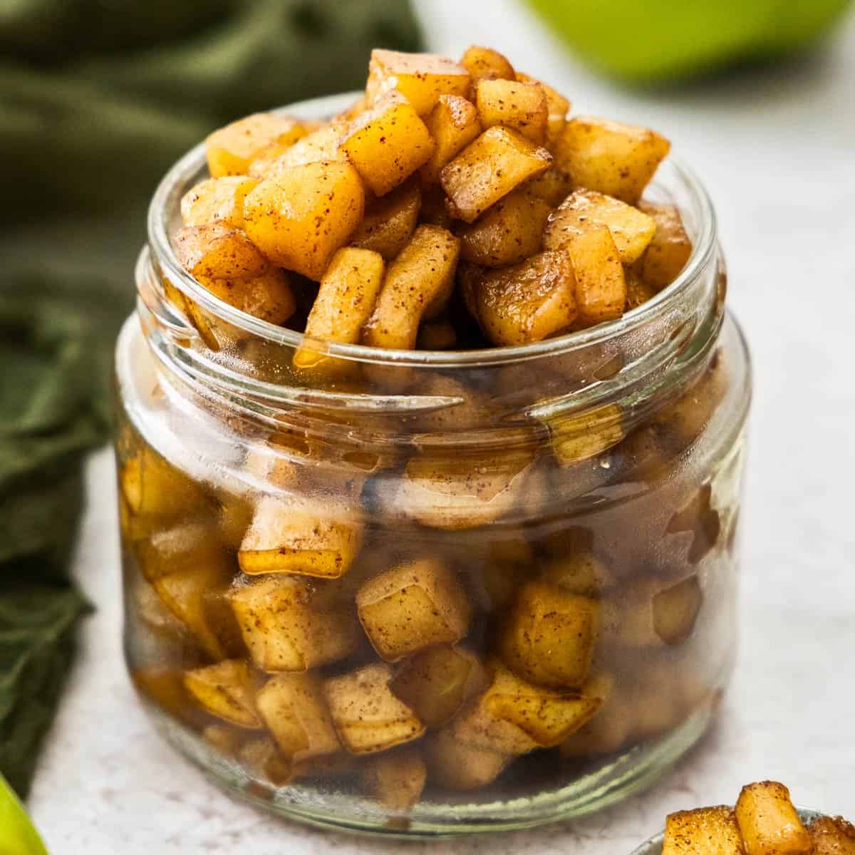 Closeup of a jar overflowing with apple compote.