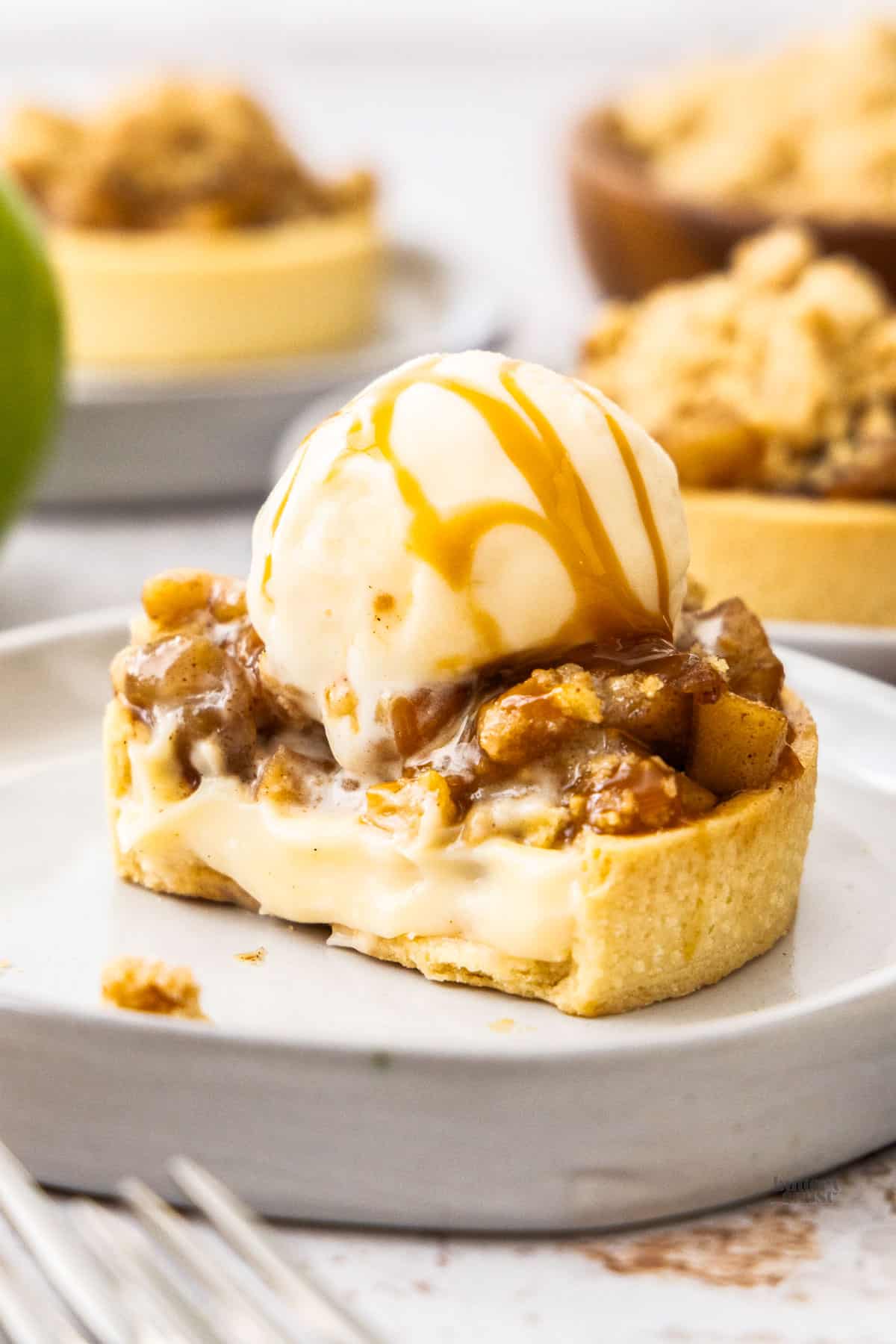 An apple custard tart cut open to show the custard filling inside.
