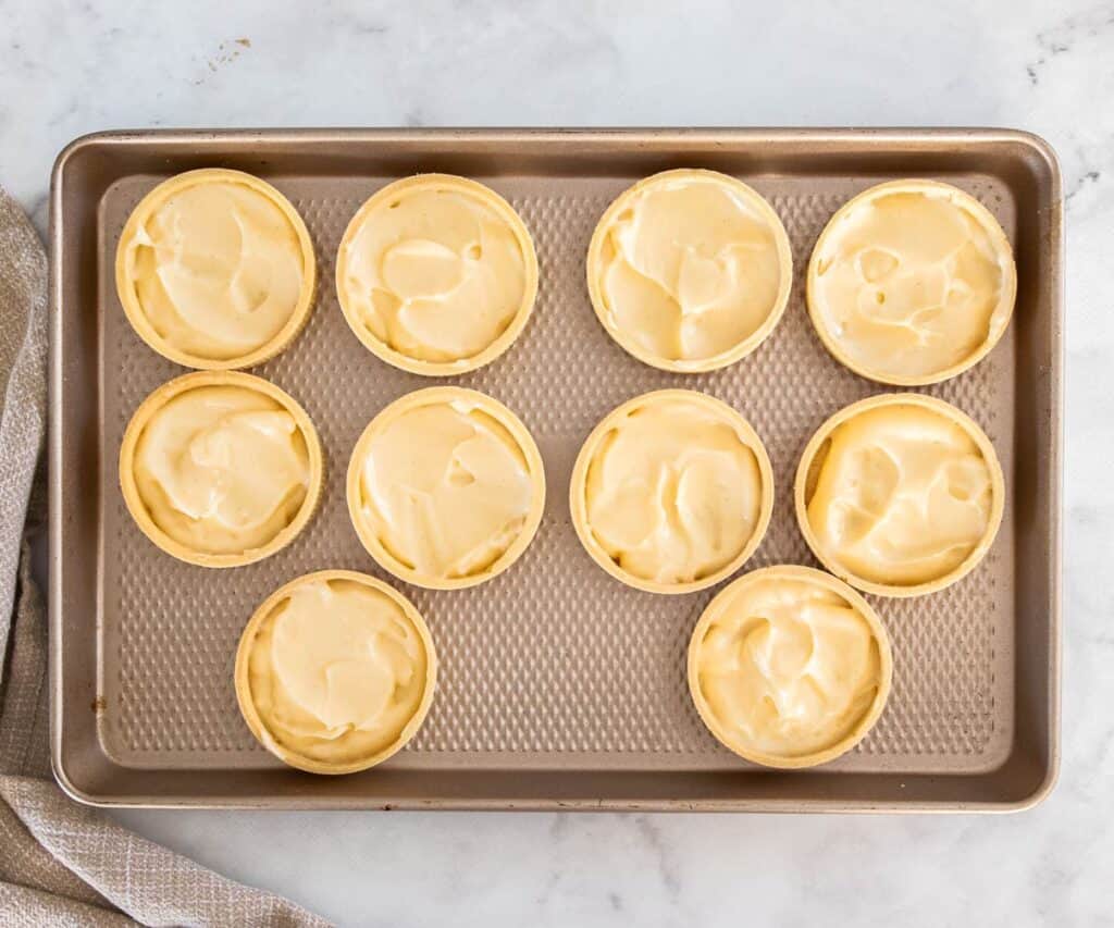 10 tart shells half filled with pastry cream.