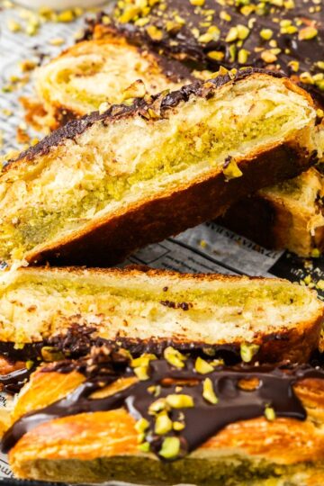 Closeup of slices of chocolate pistachio Danish braid, showing the pistachio filling centre.