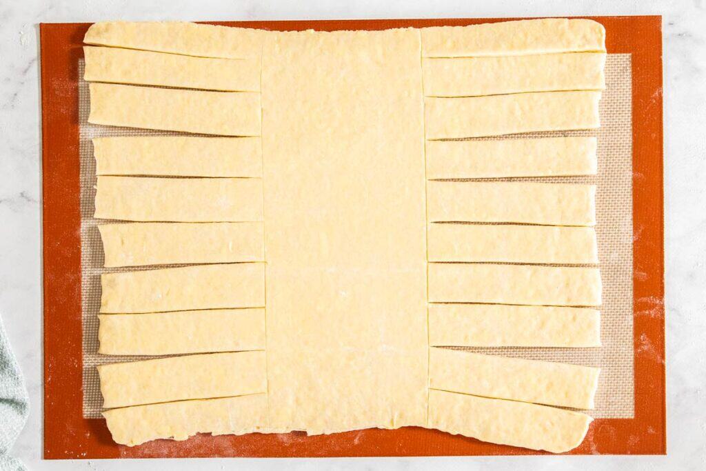 The dough with the left and right sections cut into strips.