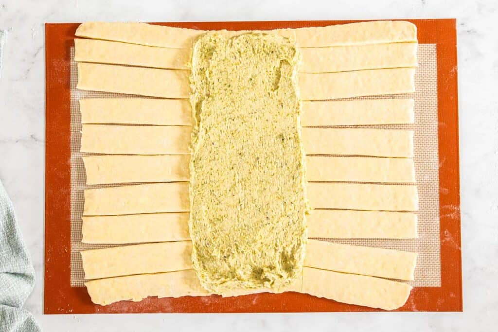 The danish braid dough with the pistachio filling spread over the centre.