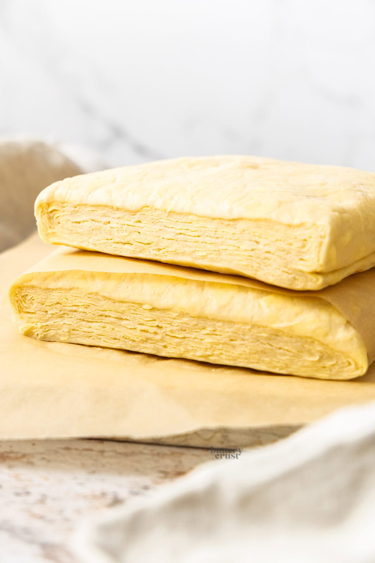 Two pieces of Danish pastry stacked and showing the layers inside.