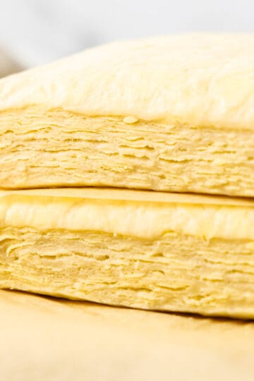 Two blocks of Danish pastry dough stacked showing the layers inside.