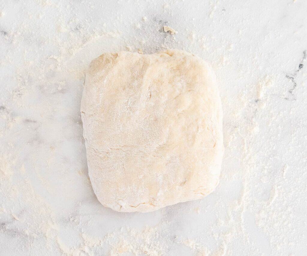 A piece of dough shaped into a rough square.