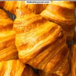 Top down view of a croissant on top of a pile of croissants.