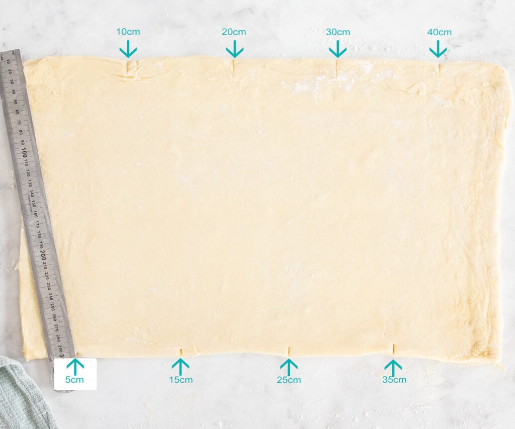 A photo with measurement marks on it showing where to mark the dough.