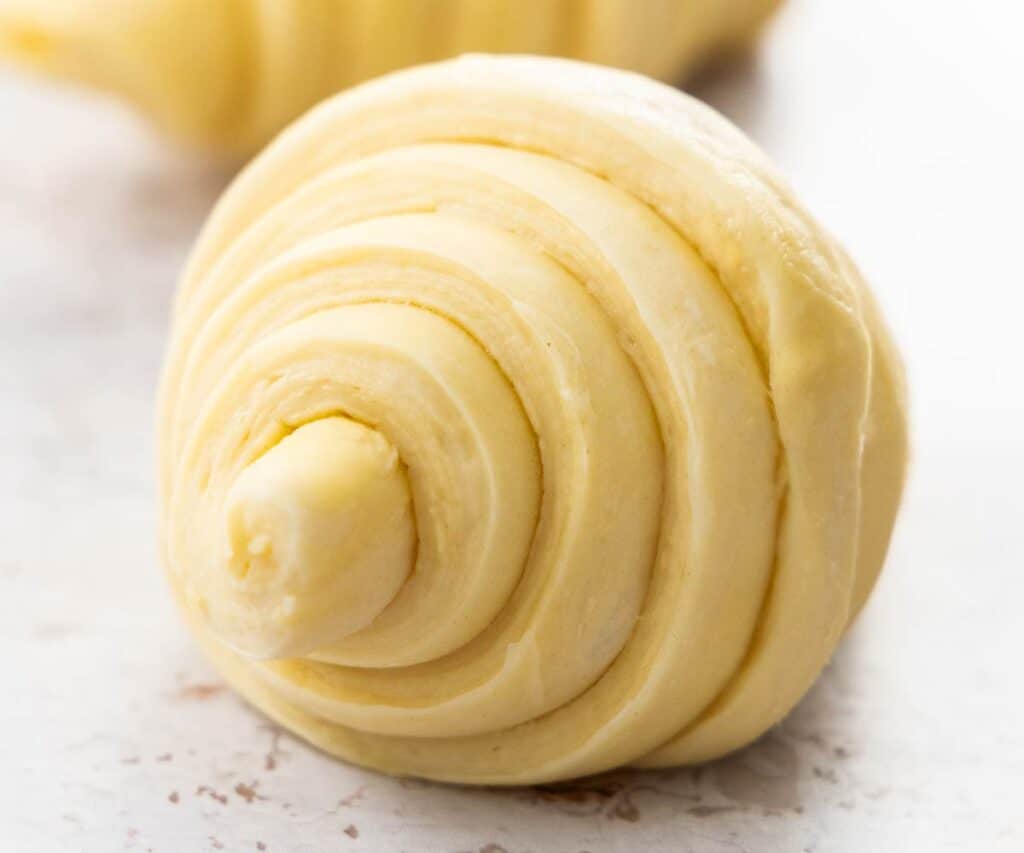 Closeup of the end of a proofed croissant ready to bake.