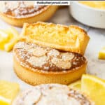 A lemon almond tart cut in half to show the almond and lemon filling inside.