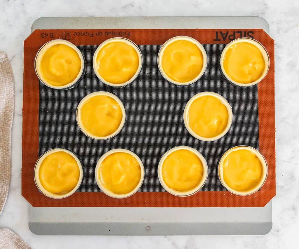 Lemon curd spread into parbaked tart shells.