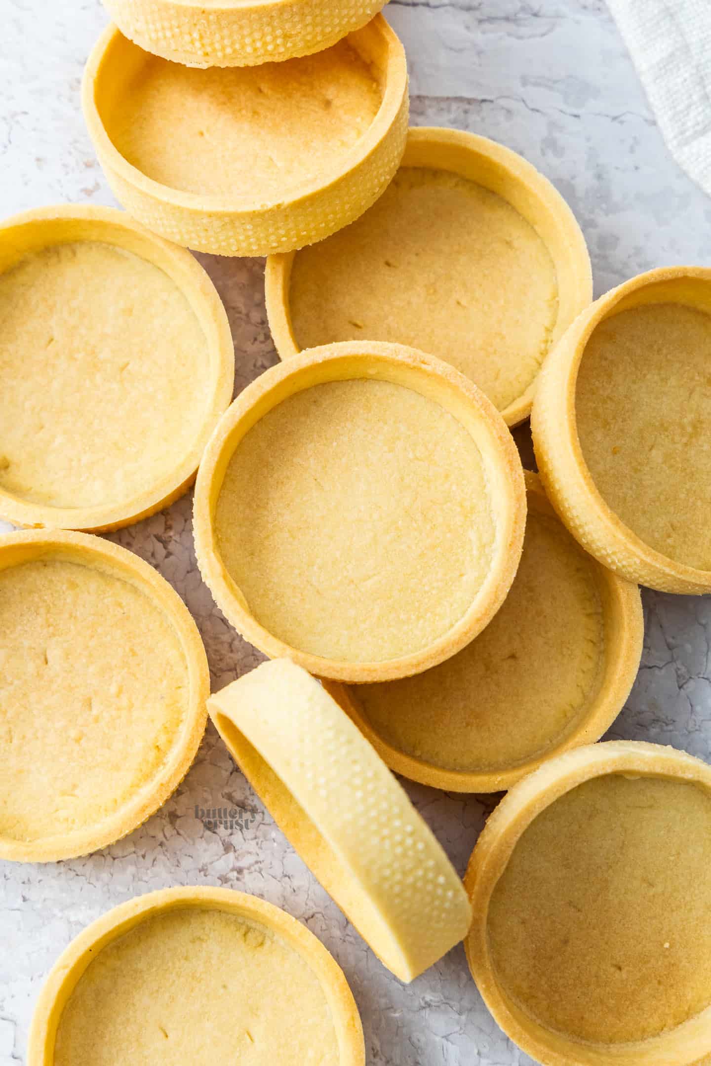 Top down view of a batch of pâte sablée tart shells.