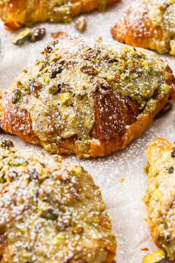 Closeup of a pistachio croissant surrounded by more.