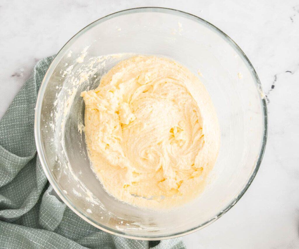 The eggs beaten into the butter in a mixing bowl.