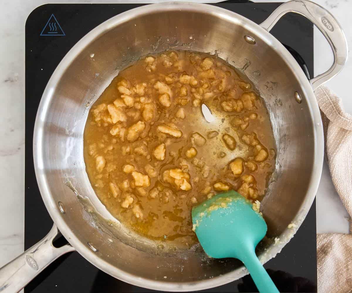 Sugar half clumped and half liquid and caramelized in a saucepan.