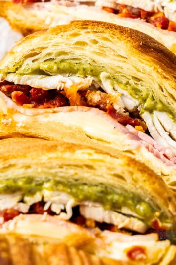 Extreme closeup of the inside of a pesto turkey croissant.