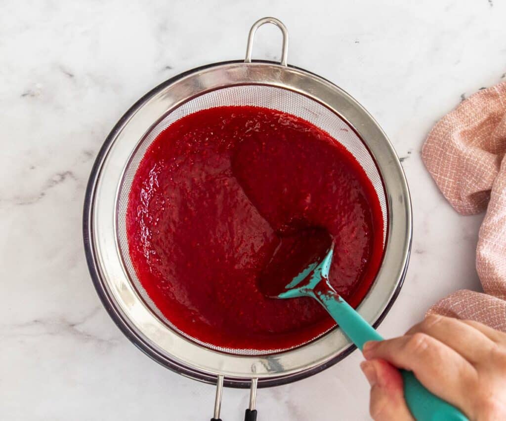 Straining the seeds from raspberry puree.