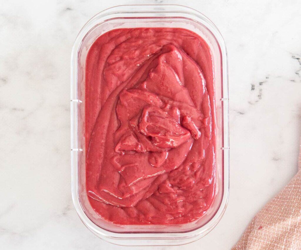 Raspberry pastry cream in a clear plastic tub.