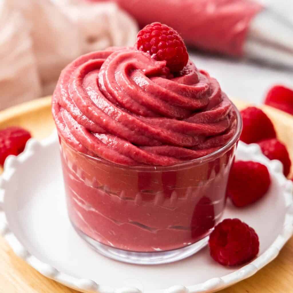 A glass filled with raspberry pastry cream.