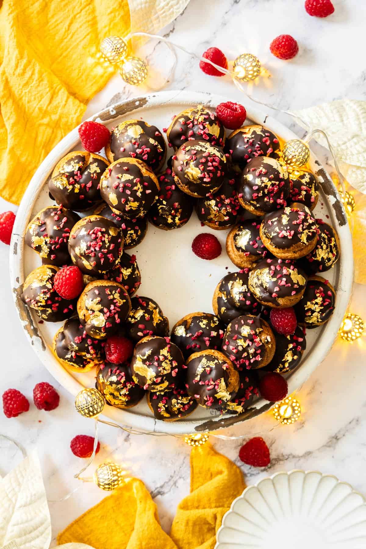 Top down view of a raspberry profiterole wreath.