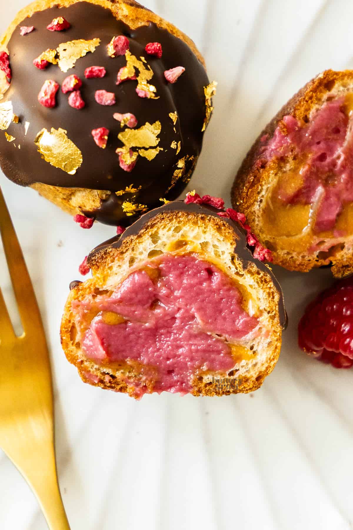 Top down view of a profiterole cut into half to show the filling inside.