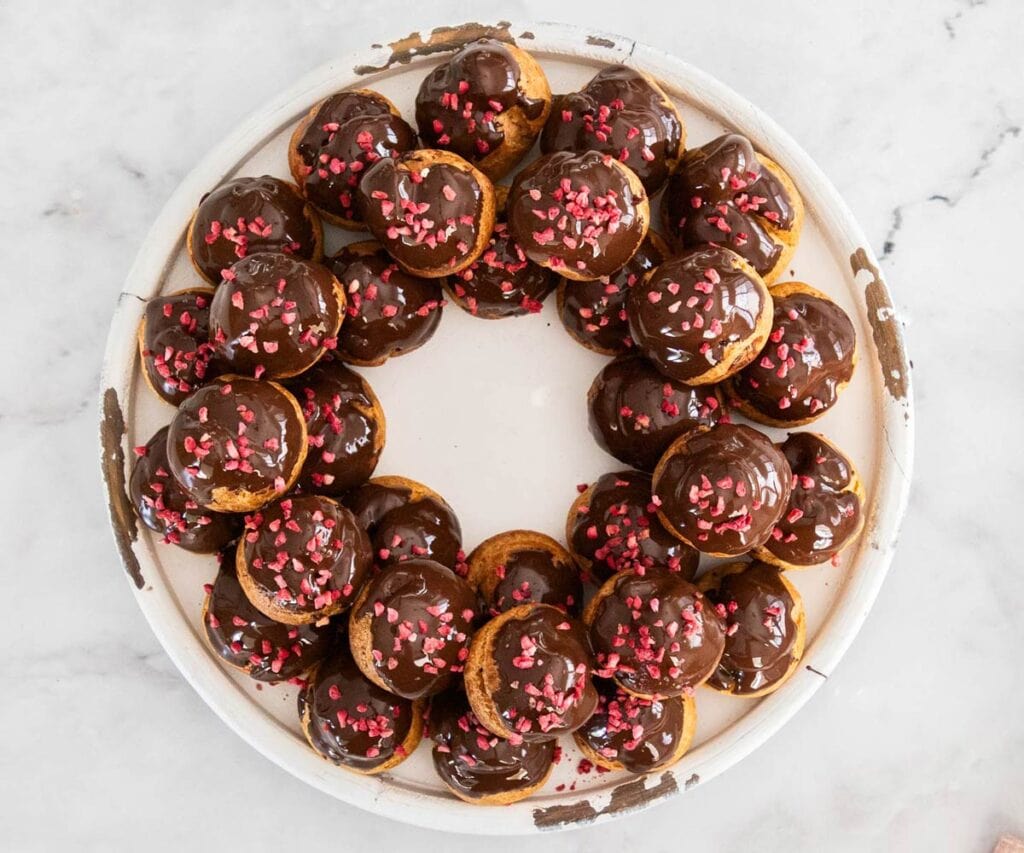 The profiterole wreath topped with freeze-dried raspberry pieces.