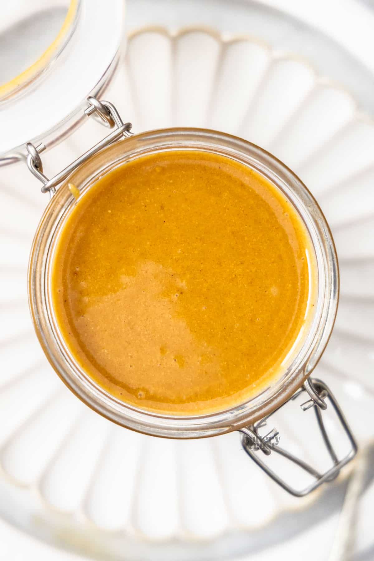 Top down view of a jar filled with hazelnut praline paste.