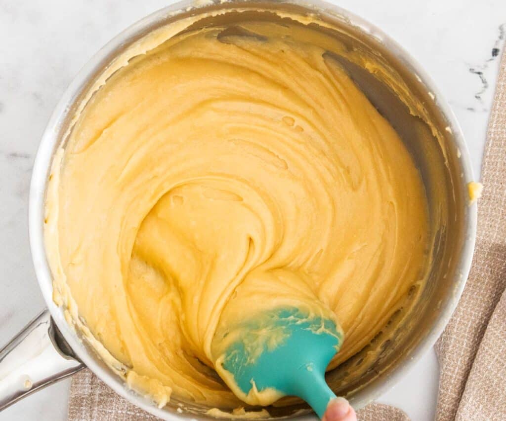 Beating eggs into choux dough.