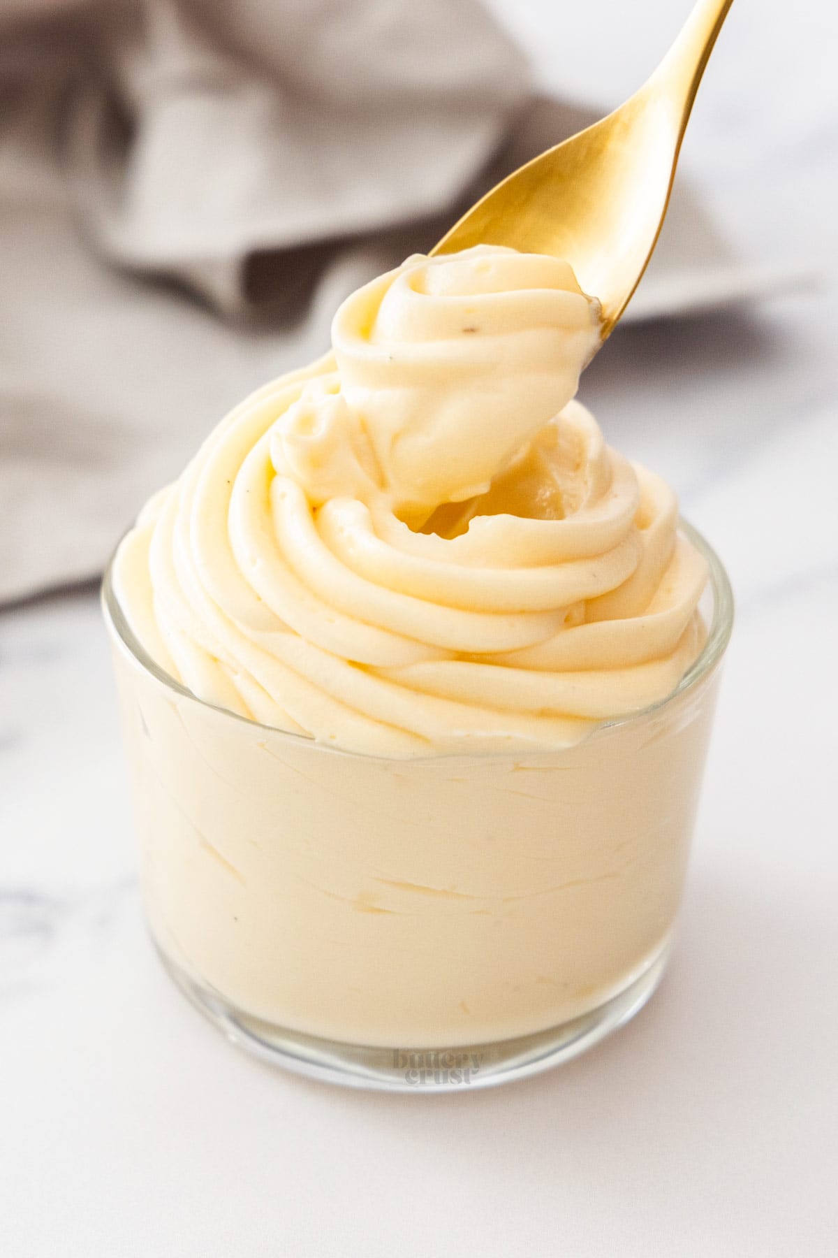 A spoon digging into a glass of creme legere.