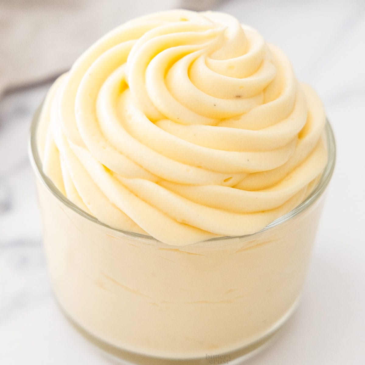 A glass with creme legere piped in a big swirl.