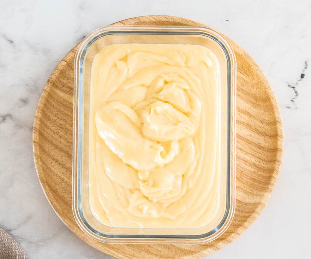 The pastry cream added to a glass dish.