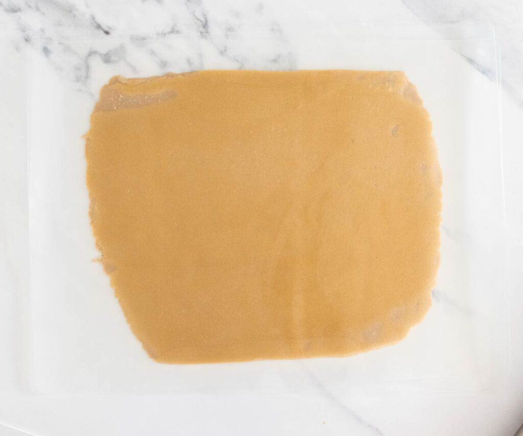 The craquelin dough rolled out between 2 silicone sheets.