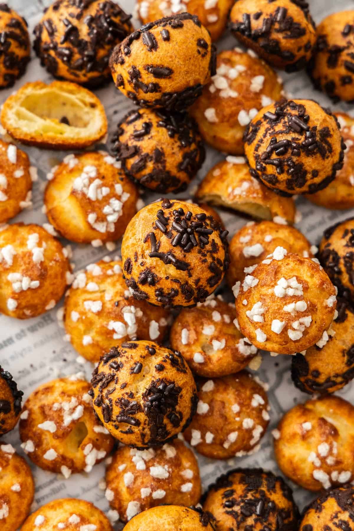 Top down view of a mixture of classic and chocolate chouquettes all piled up.