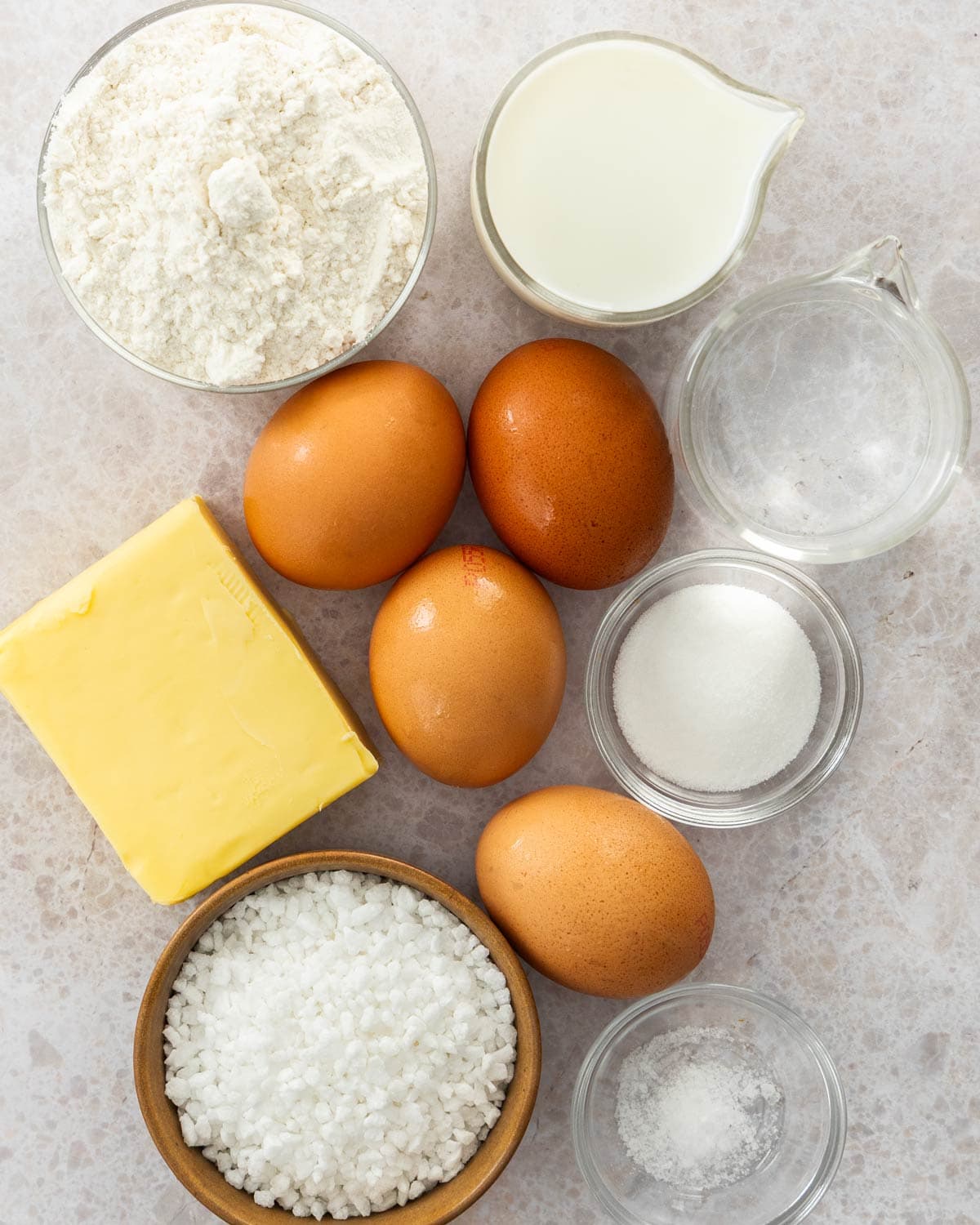 Ingredients for chouquettes on a stone surface.