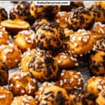 A pile of mixed chouquettes - some with pearl sugar, some with chocolate sprinkles.