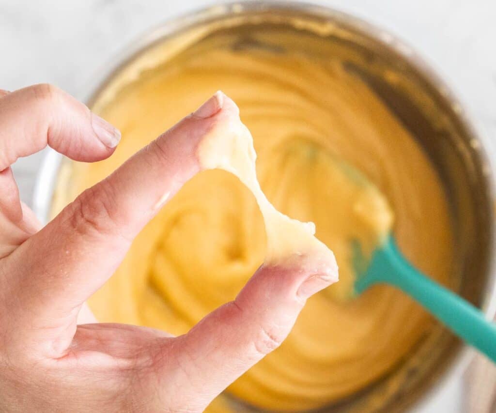 The pinch test showing the dough stretched between finger and thumb.