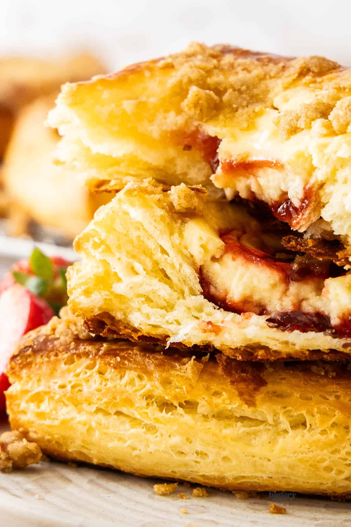 Closeup of the inside of the strawberry cheesecake Danish pastry showing the layers of pastry.