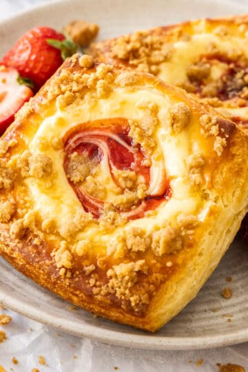 Closeup of 2 strawberry cheesecake Danish pastries on a plate.