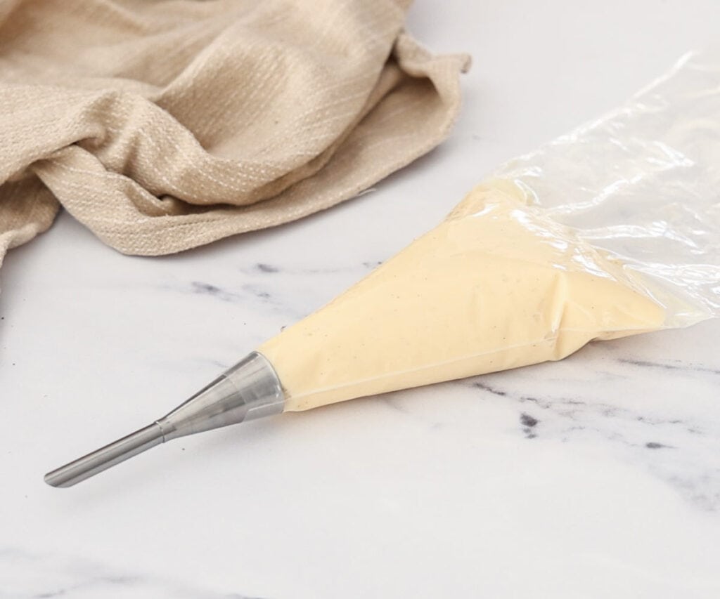 Vanilla pastry cream in a piping bag with a bismarck piping tip.