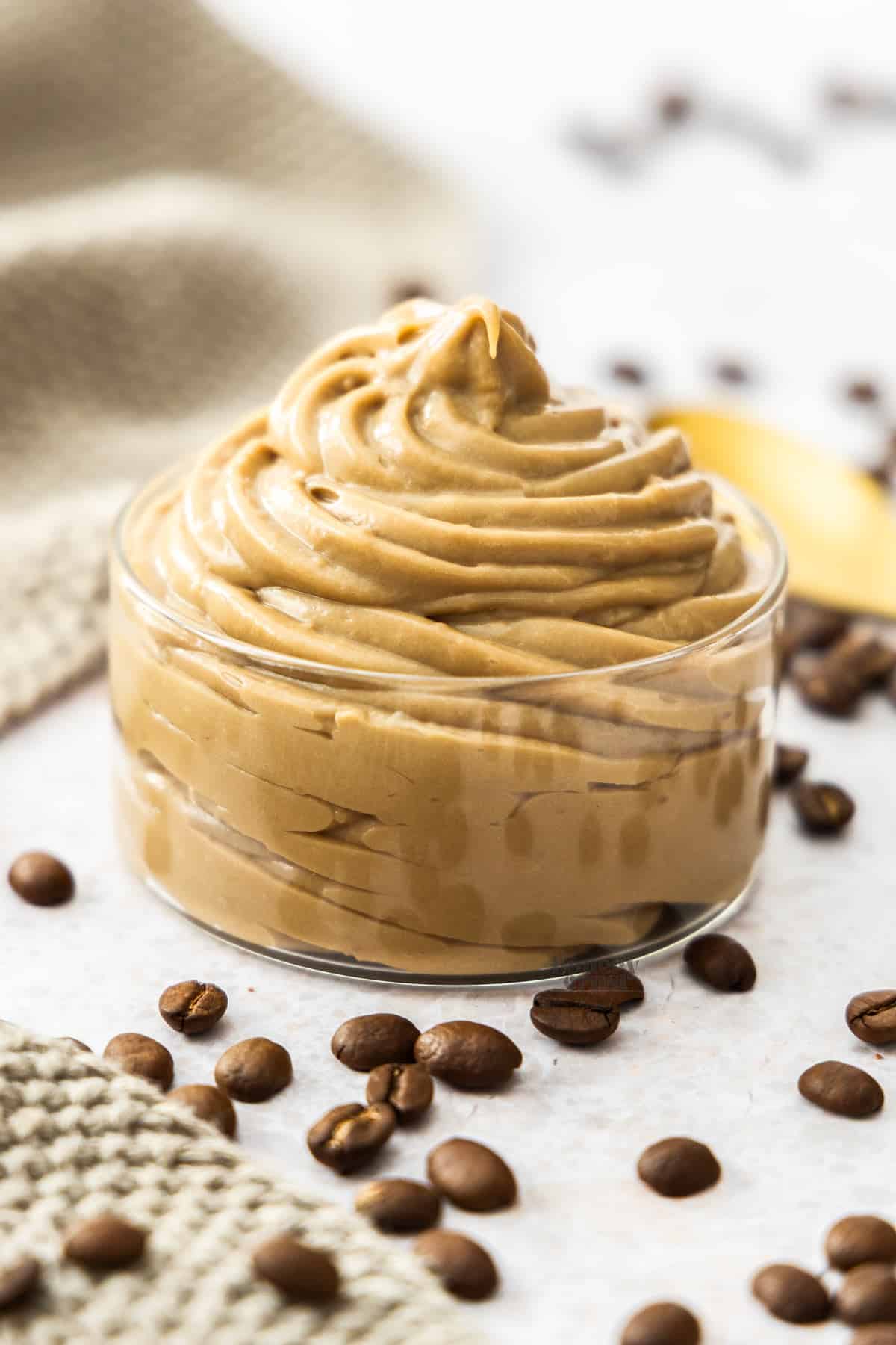 A glass dish filled with a big swirl of coffee pastry cream.