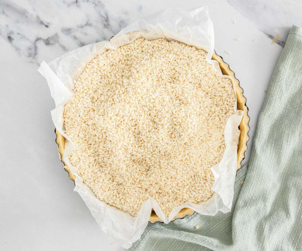 The tart shell filled with rice, ready for baking.