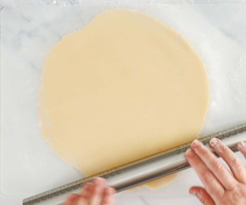 Pastry dough being rolled out between two silicone mats.