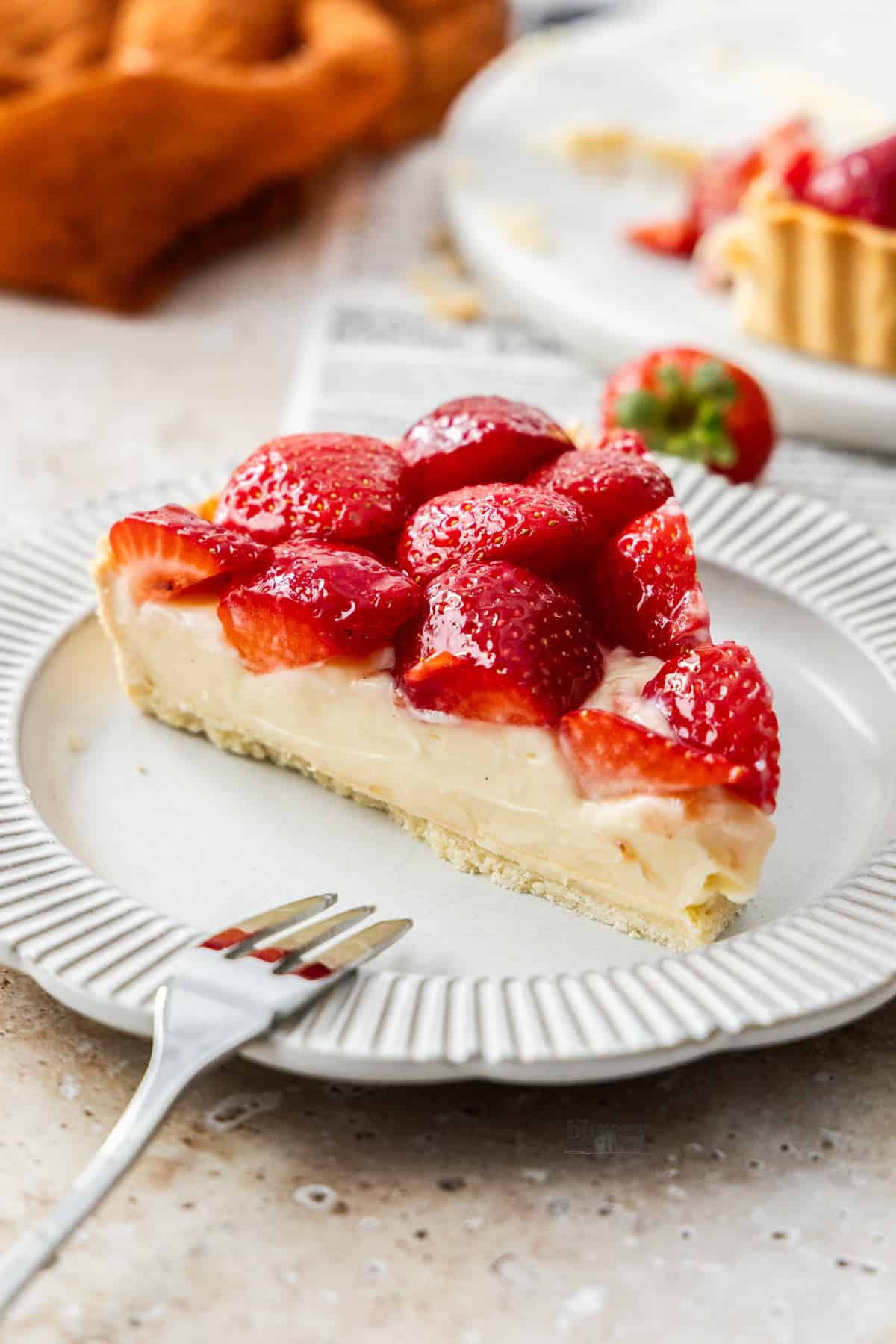 A slice of French strawberry tart on a dessert plate.