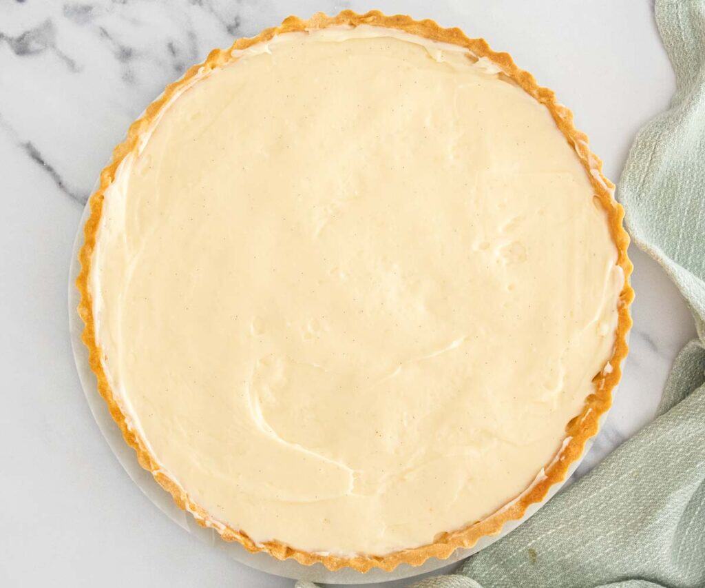 The baked tart shell filled with pastry cream.