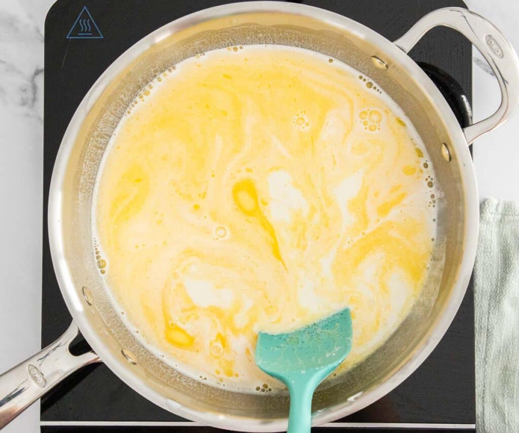 The butter melting into the milk as it heats.